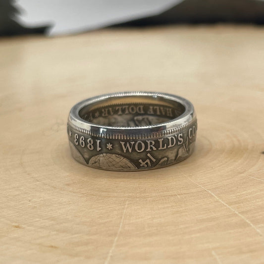 U.S. 1892-1893 Chicago Columbus Silver Half Dollar Coin Ring (patina) on a light wood round.