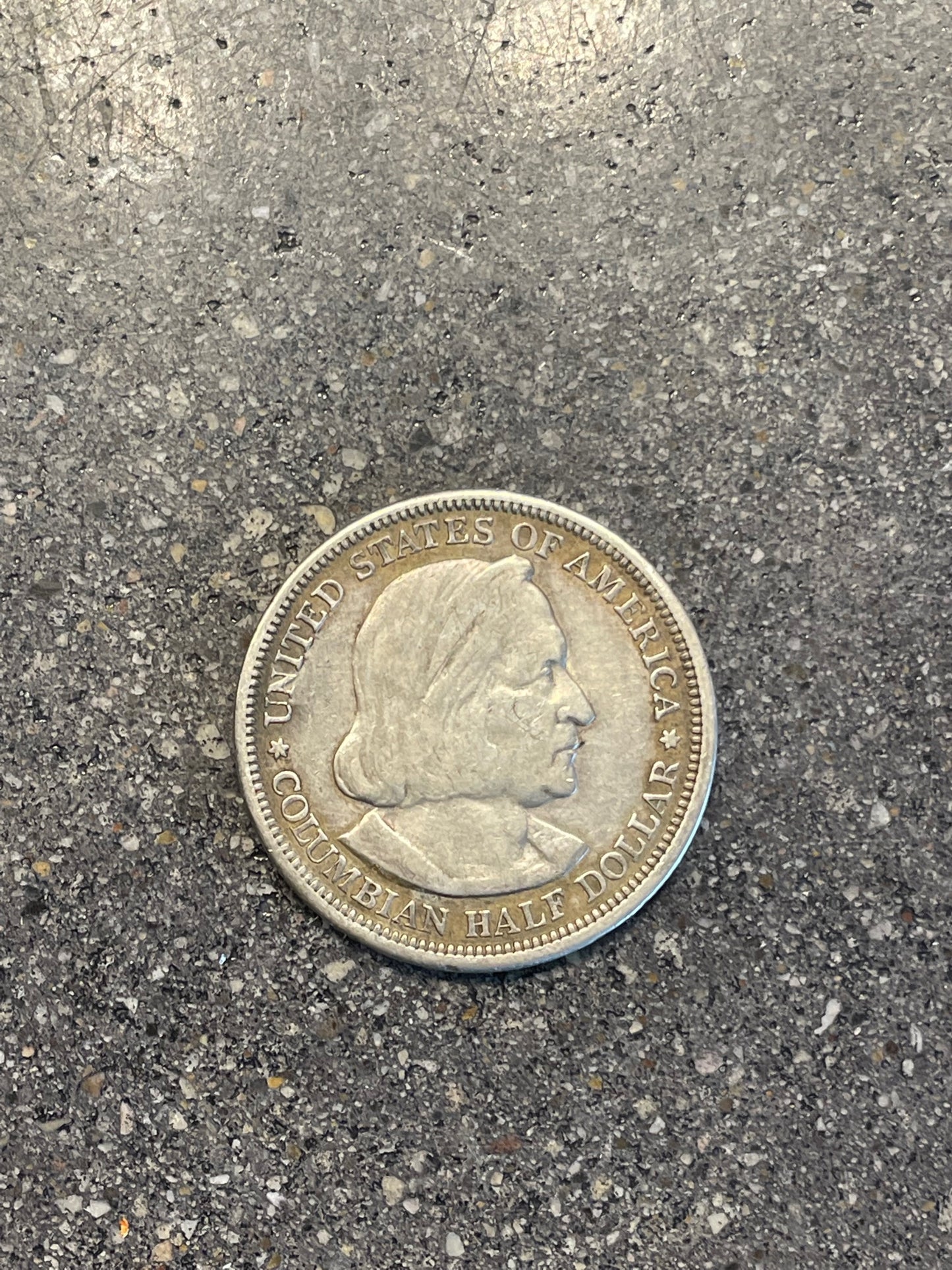 U.S. 1892-1893 Chicago Columbus Silver Half Dollar Coin front on a concrete background.  - Mountainstruck Coin Jewelry