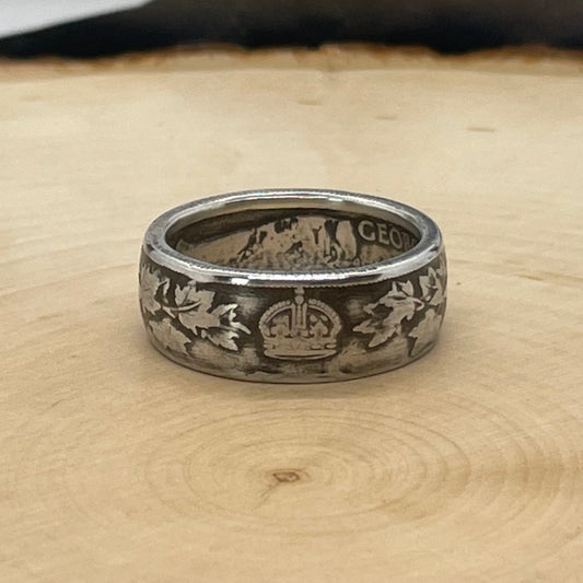 Canada 50 Cents Maple Leaf Silver Ring on a light wood round with a mountain outline background. - Mountainstruck Coin Jewelry