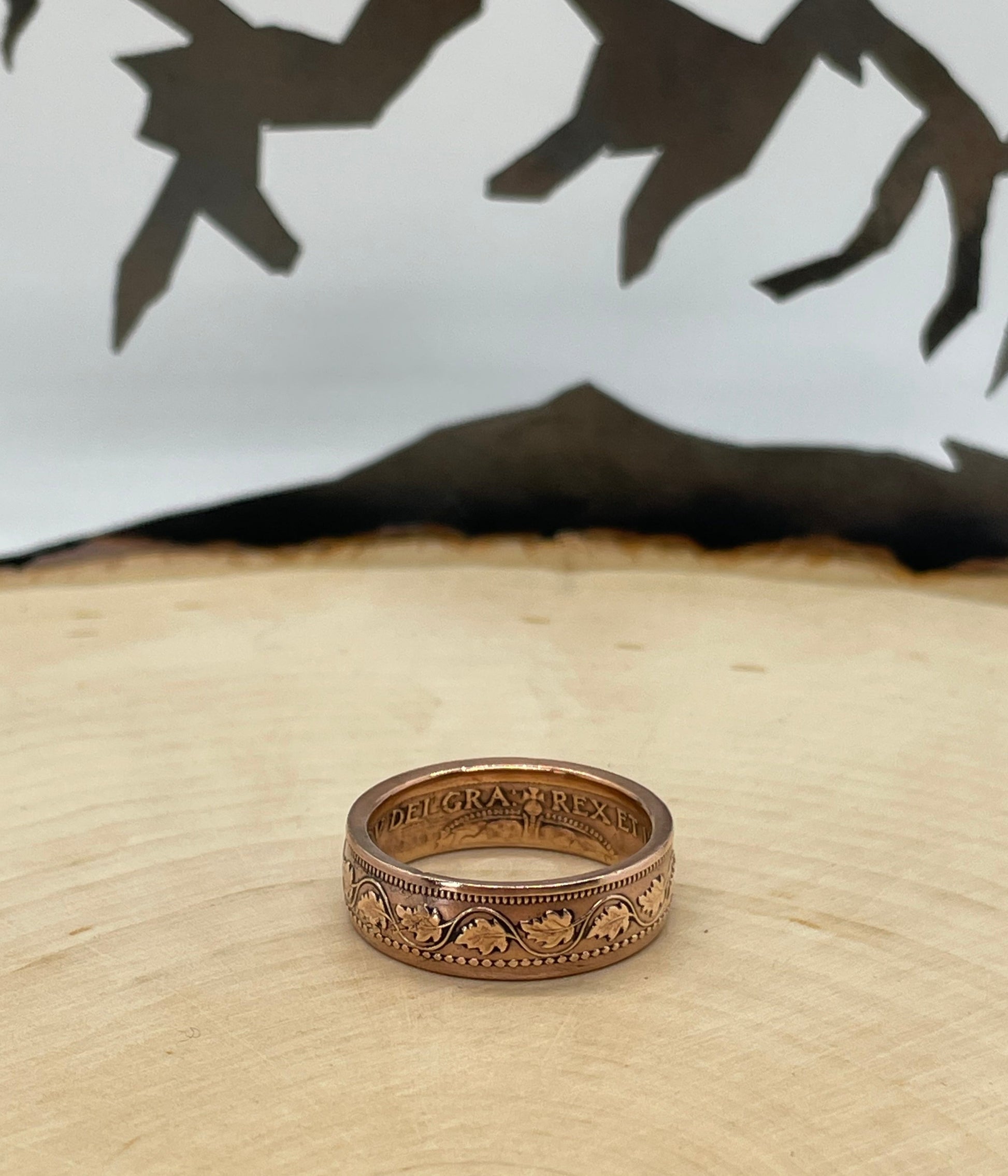 Canada Large Cent Leaf Coin Ring on a light wood round with a mountain outline background. - Mountainstruck Coin Jewelry