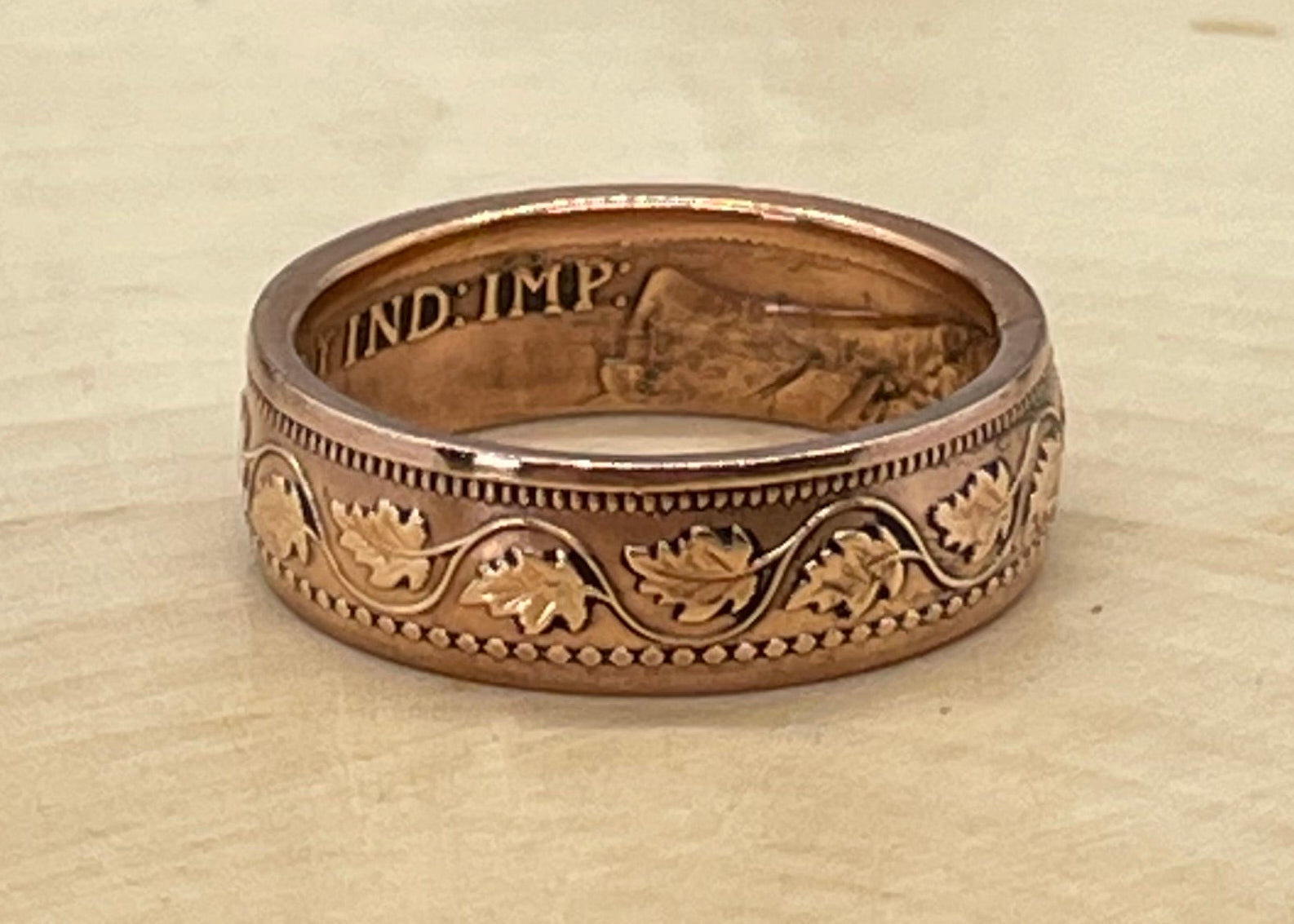 Canada Large Cent Leaf Coin Ring on a light wood round with a mountain outline background. - Mountainstruck Coin Jewelry