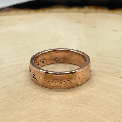 Denmark 5 Øre Coin Ring on a light wood round with a mountain outline background. - Mountainstruck Coin Jewelry