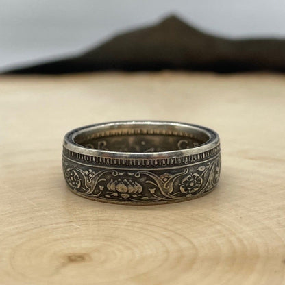 India Half Rupee Silver Coin Ring on a light wood round with mountain outline in the background. - Mountainstruck Coin Jewelry