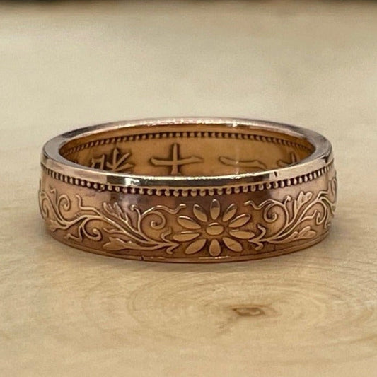 Japan One Sen Coin Ring on a light wood round with mountain outline in the background. - Mountainstruck Coin Jewelry