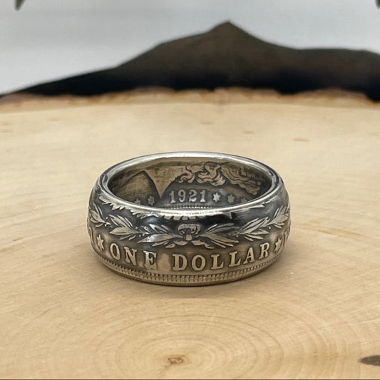 Morgan Dollar Silver Coin Ring on a light wood round with mountain outline in the background. - Mountainstruck Coin Jewelry