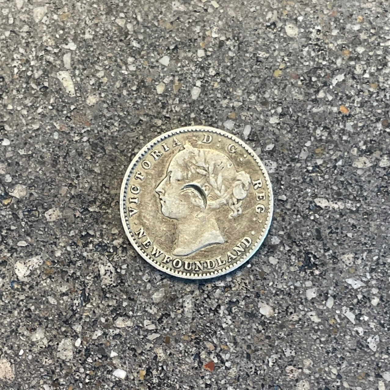 Newfoundland 10 Cents Silver Coin front on a concrete surface. - Mountainstruck Coin Jewelry