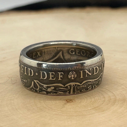 UK Half Crown Silver Coin Ring (1927-1936, G.B.) on a light wood round with mountain outline in background. - Mountainstruck Coin Jewelry
