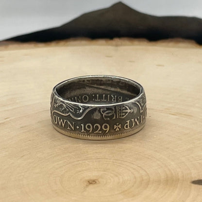 UK Half Crown Silver Coin Ring (1927-1936, G.B.) on a light wood round with mountain outline in background. - Mountainstruck Coin Jewelry
