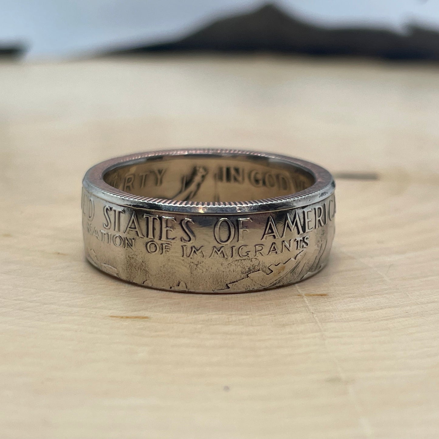"A Nation of Immigrants" Half Dollar Coin Ring shined on light wood round. - Mountainstruck Coin Jewelry