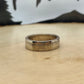 Sacagawea Dollar Coin Ring on a light wood round with mountain outline in background. - Mountainstruck Coin Jewelry