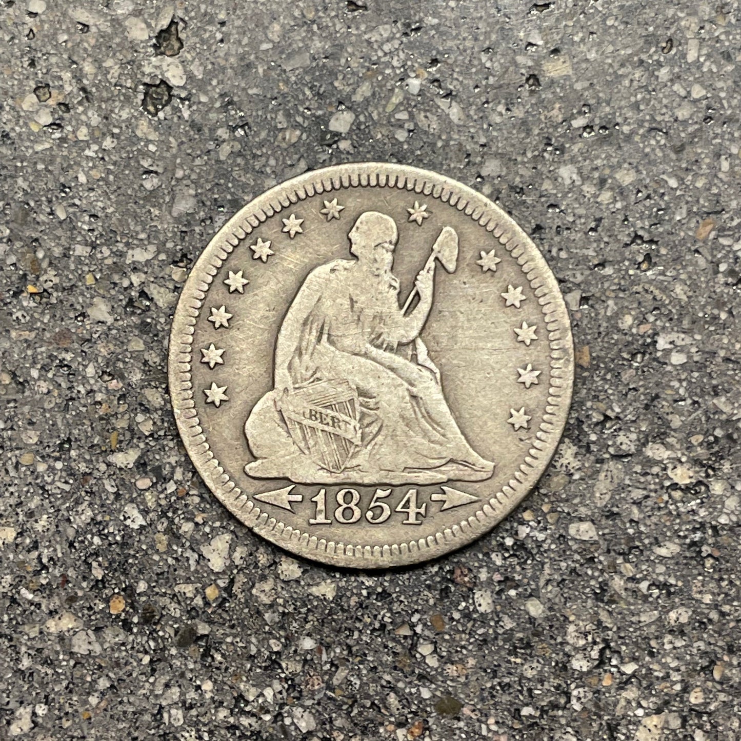 Seated Liberty Silver Quarter Coin front on a concrete background. - Mountainstruck Coin Jewelry