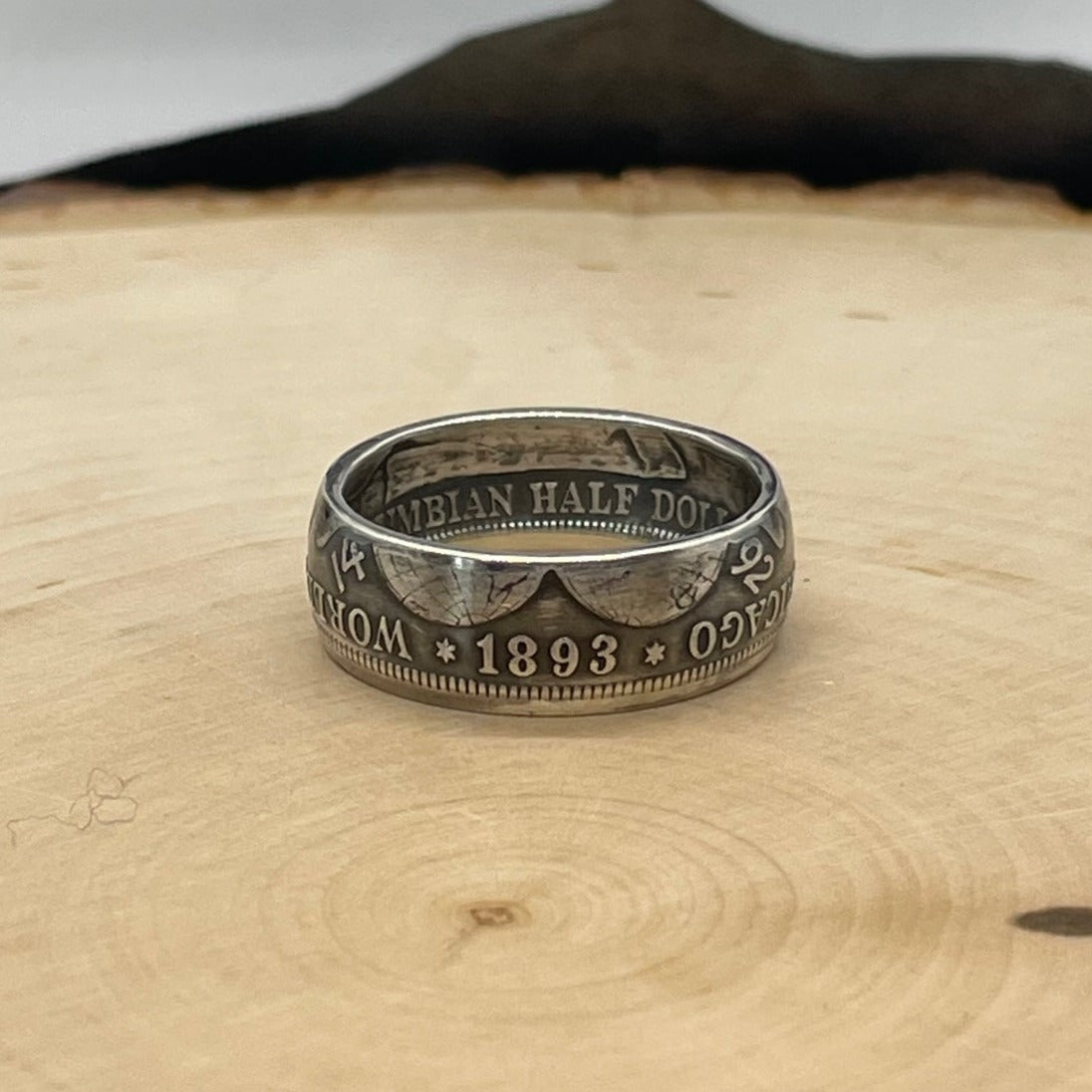 U.S. 1892-1893 Chicago Columbus Silver Half Dollar Coin Ring (patina) on a light wood round. - Mountainstruck Coin Jewelry