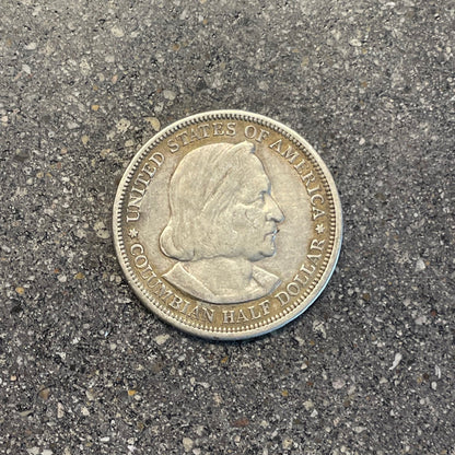U.S. 1892-1893 Chicago Columbus Silver Half Dollar Coin front on a concrete background.  - Mountainstruck Coin Jewelry