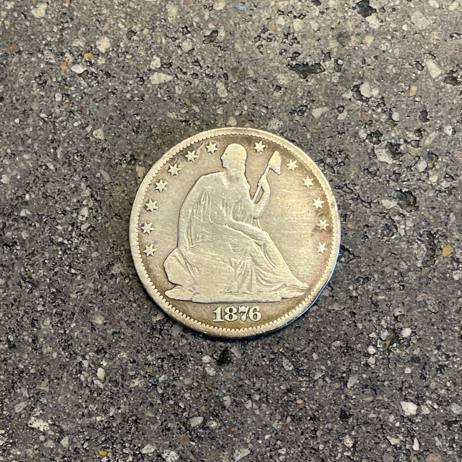 U.S. Seated Liberty Silver Half Dollar Coin front on a concrete background. - Mountainstruck Coin Jewelry