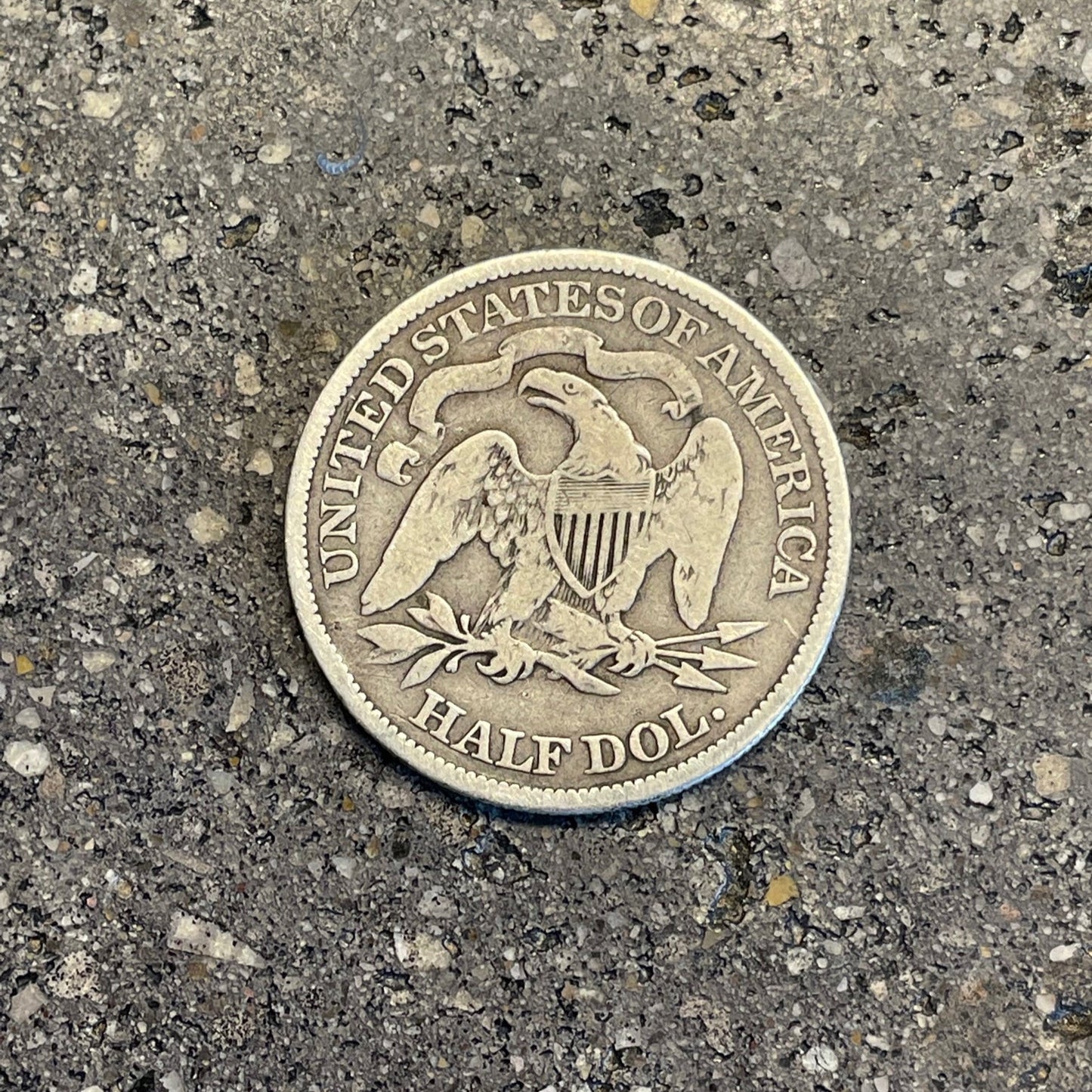 U.S. Seated Liberty Silver Half Dollar Coin back on a concrete background. - Mountainstruck Coin Jewelry