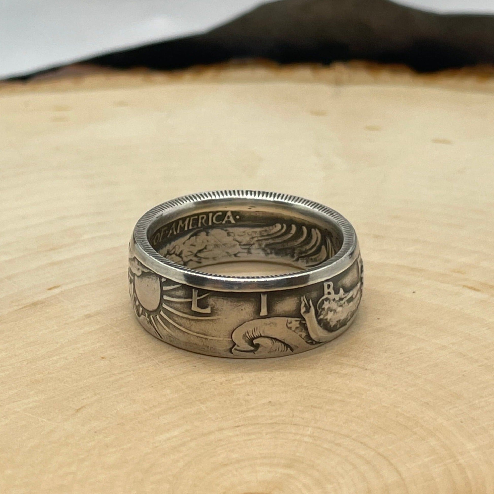 Walking Liberty Half Dollar Silver Coin Ring on a light wood round. - Mountainstruck Coin Jewelry