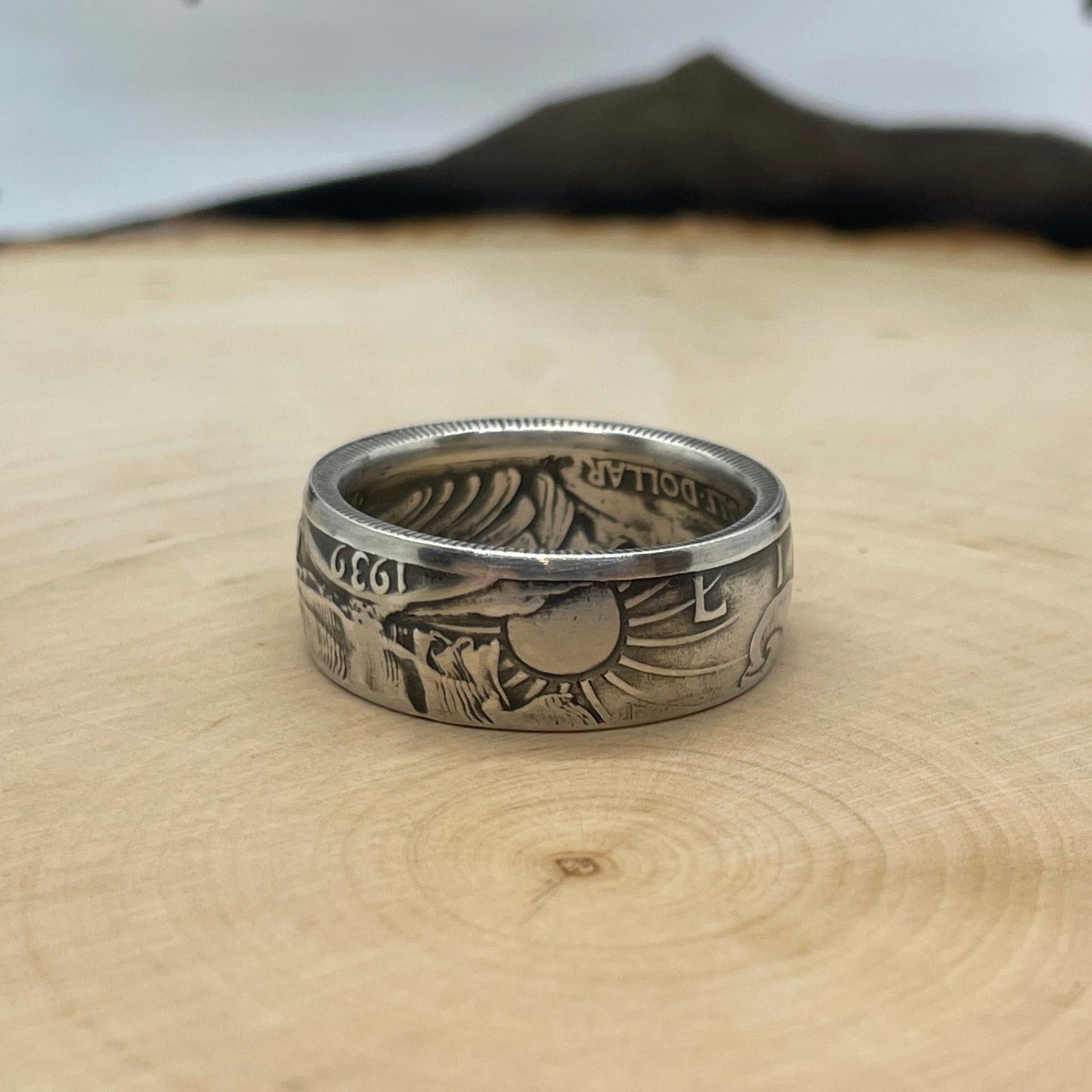 Walking Liberty Half Dollar Silver Coin Ring on a light wood round with a mountain outline in the background. - Mountainstruck Coin Jewelry