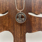U.S. First American Woman in Space Coin Necklace with a snake chain on a wood tree background.