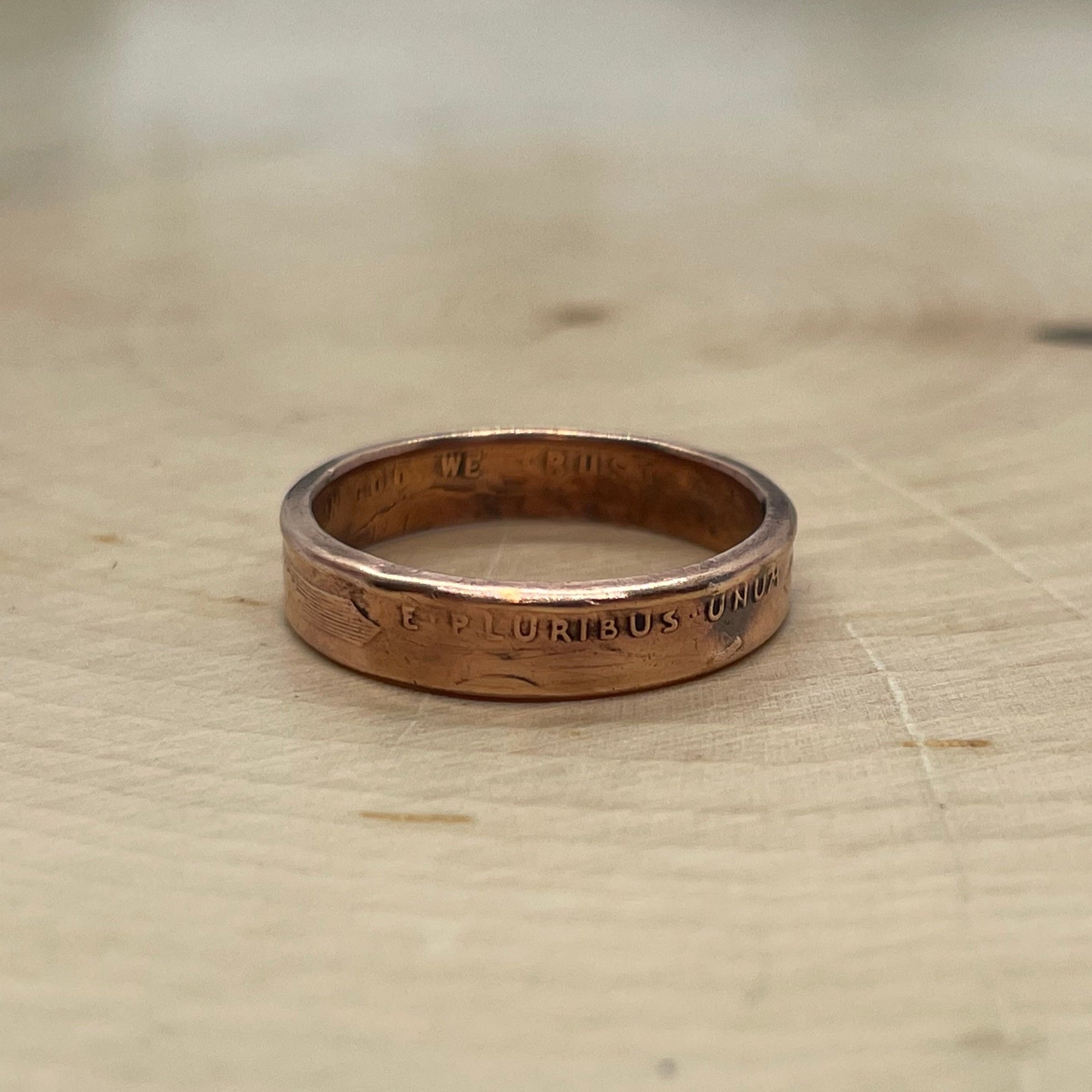 Wheat Penny Coin Ring on a light wood round.