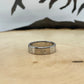 Canada 25 Cents Silver Coin Ring on a light wood round with a mountain outline background.