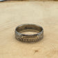 UK One Shilling Silver Coin Ring on a light wood round.