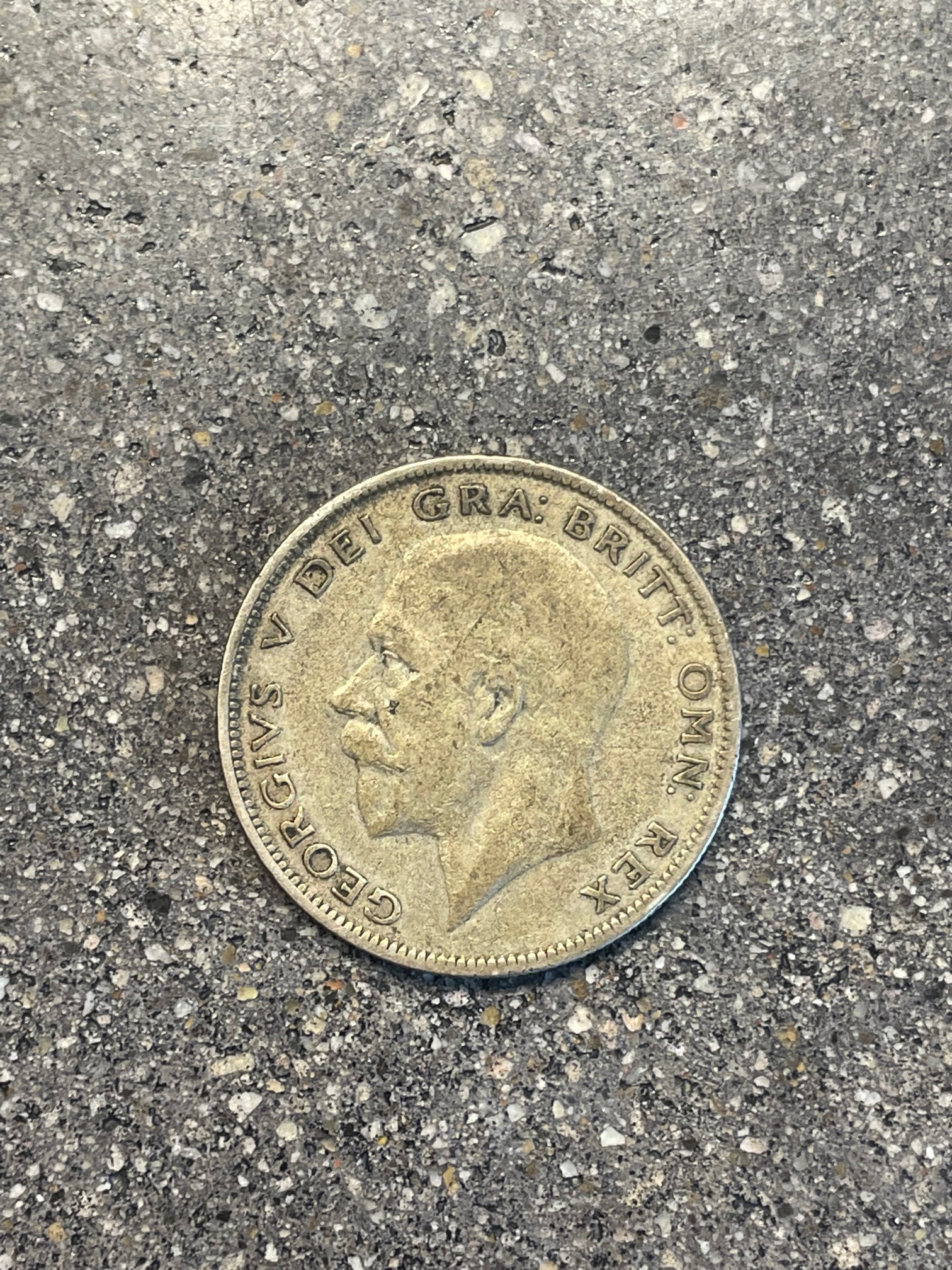 UK Half Crown Silver Coin front on a concrete background.