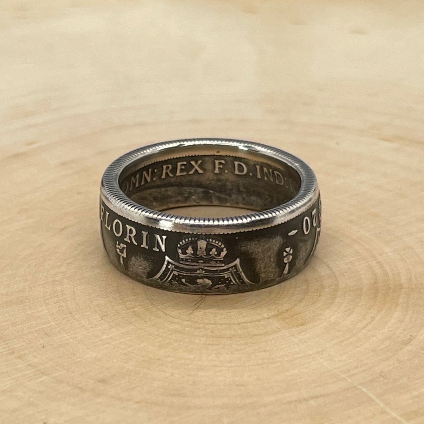 UK One Florin Silver Coin Ring on a light wood round.