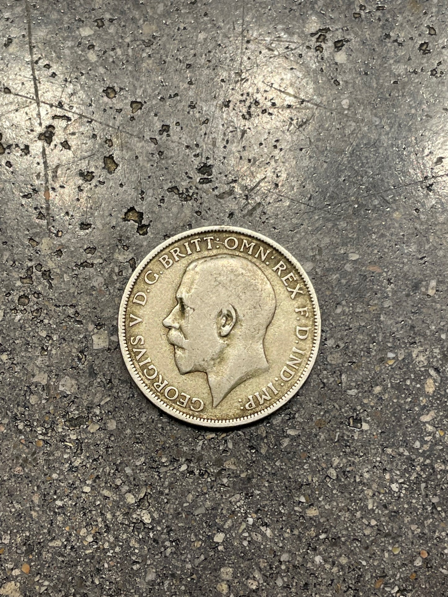UK One Florin Silver Coin front on a concrete background.