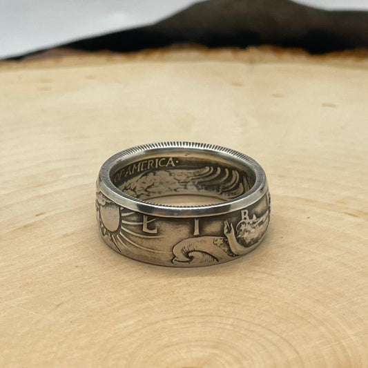 Walking Liberty Silver Half Dollar Coin Ring on a light wood round.